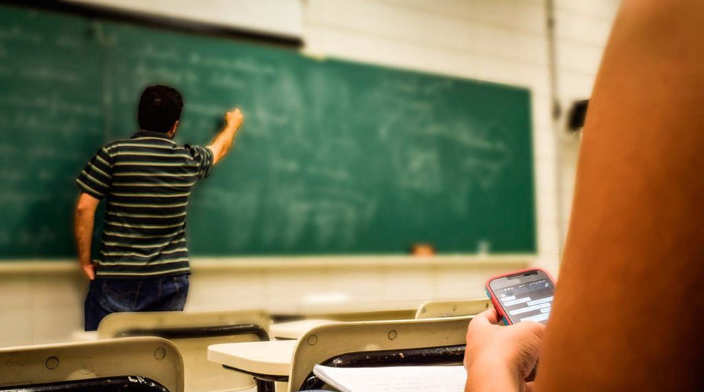 Professor dando aula de costas, ilustração do impacto da licença médica na promoção e quinquênio